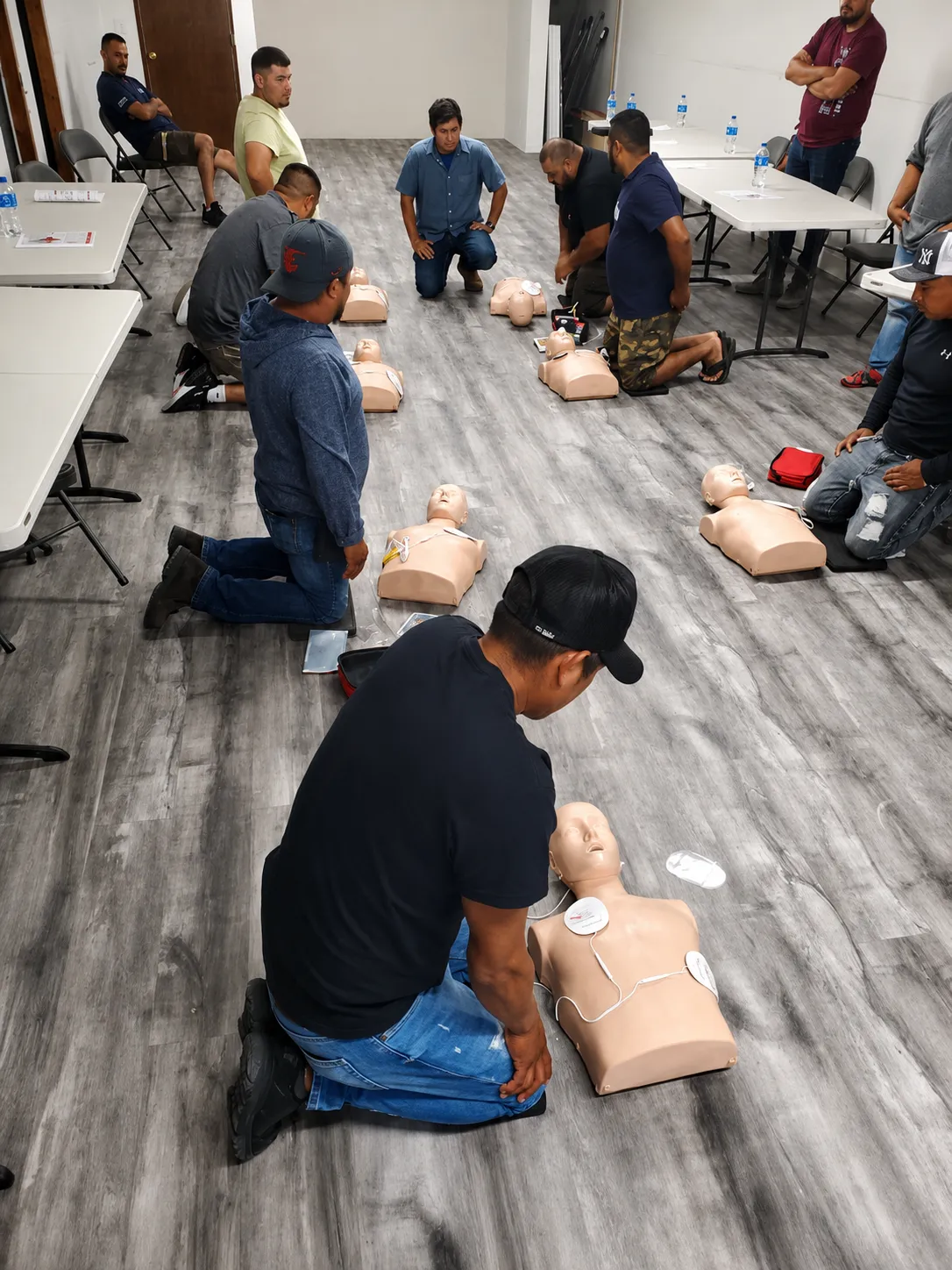 Workers practicing CPR on training manikins during an ACMAN Solutions First Aid certification course